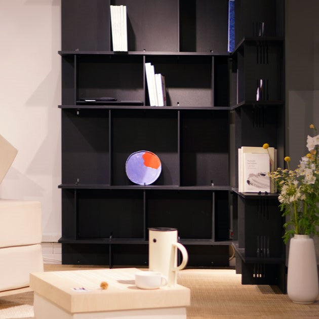 Eckregal schwarz als Raumtrenner im Wohnzimmer